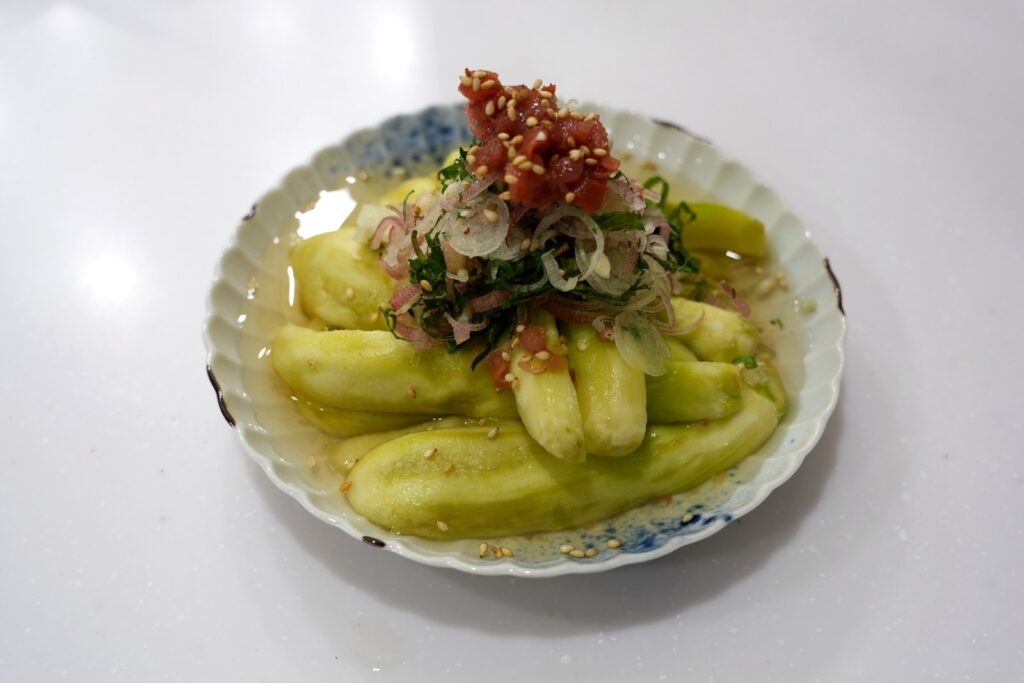 ナスの梅浸し。皮をむいて手で裂いたなすに、たたき梅・大葉・みょうがをのせた冷たい一品