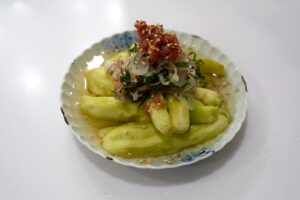 ナスの梅浸し。皮をむいて手で裂いたなすに、たたき梅・大葉・みょうがをのせた冷たい一品