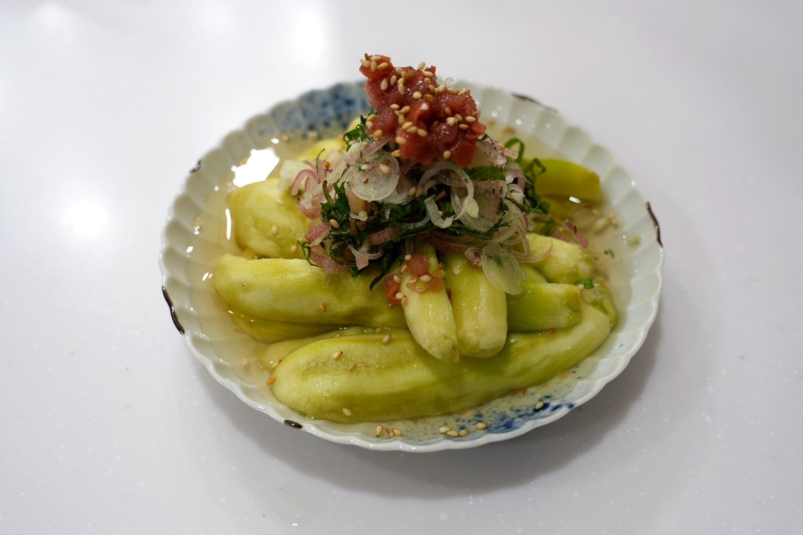 ナスの梅浸し。皮をむいて手で裂いたなすに、たたき梅・大葉・みょうがをのせた冷たい一品